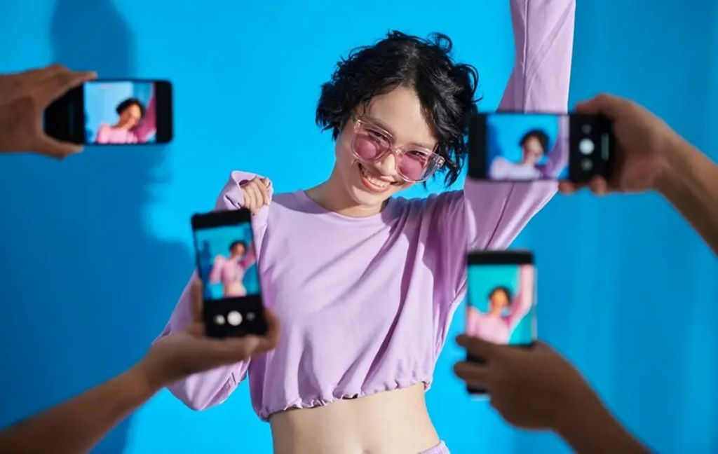 Person watching TikTok clips on a laptop and smartphone browser without the TikTok app installed