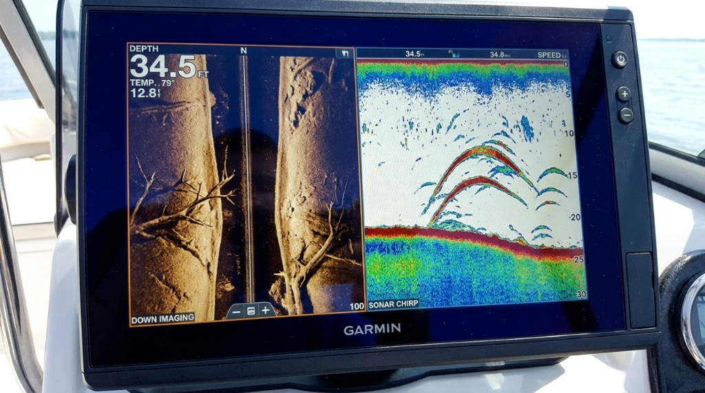 A smiling fisherman holding a fish with a sonar screen background.